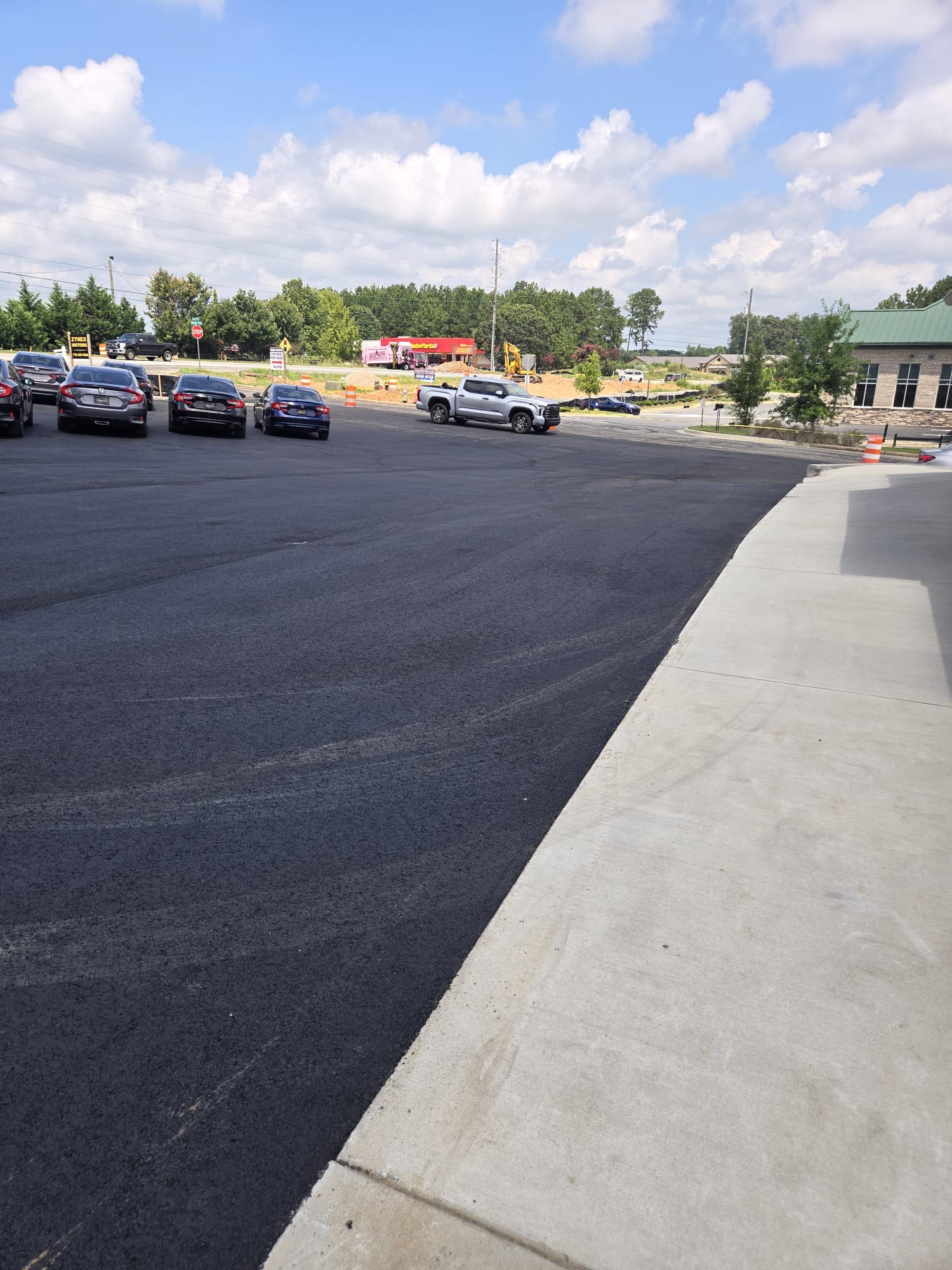 New asphalt lot meeting a poured concrete sidewalk