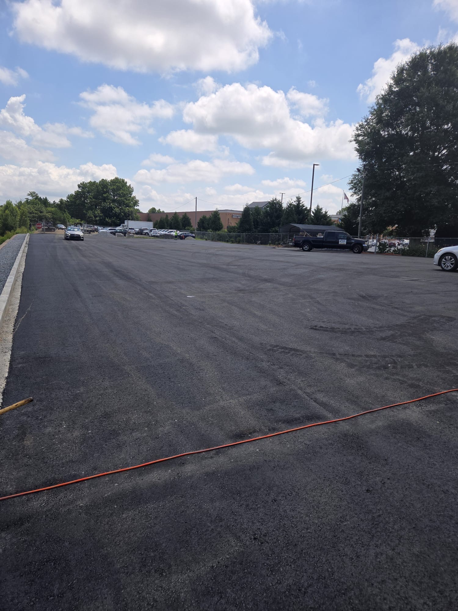 Large newly paved parking lot with fresh curbing